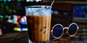 믹스커피, 테이블 위에 얼음이 들어가 있는 커피가 올려져 있고, 옆에 선글라스가 보이는 사진