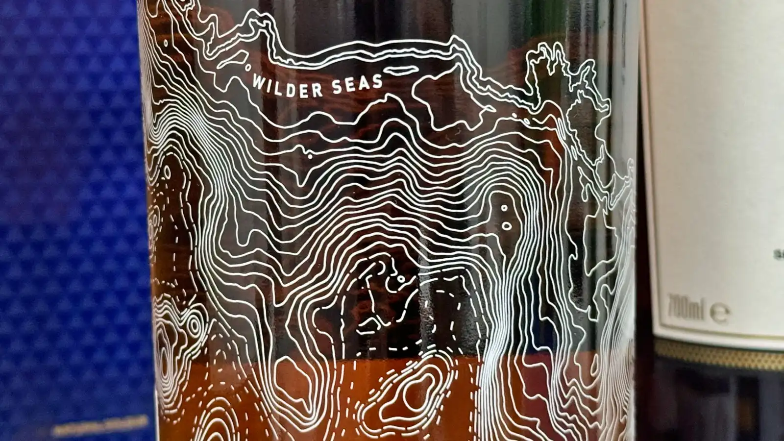 탈리스커 와일더 씨 팔리 에디션 유리병 겉면에 그려진 해안선 문양이 보이는 사진